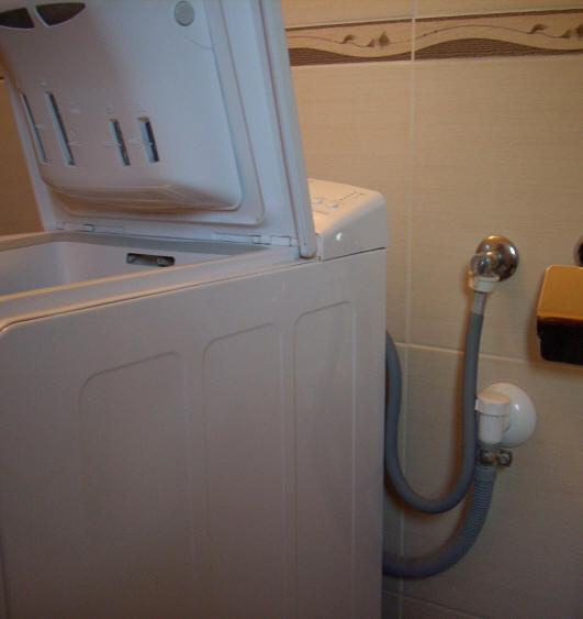 подключенная автоматическая стиральная машинка к водопроводу и канализации.