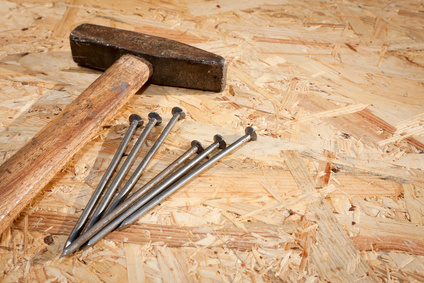 Hammer and nails over hardboard background