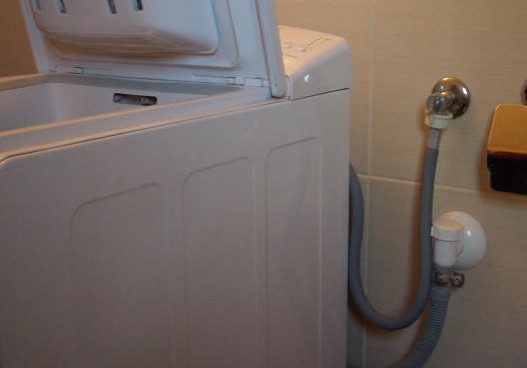подключенная автоматическая стиральная машинка к водопроводу и канализации.